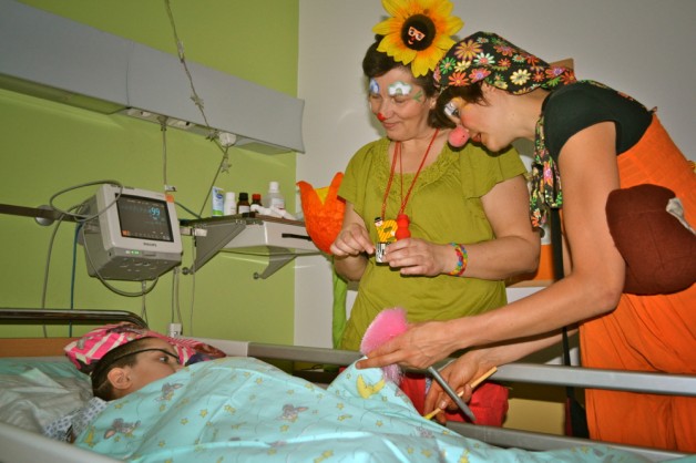 Mediclowns in Aktion Blümi und Olivia Olivia und Blümi sind am Bett eines Kindes ins Spiel vertieft. | Bild: Mediclowns e.V.