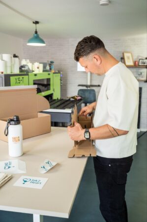 Richard Müller verpackt personalisierte Thermoflaschen in der Ink2Heart-Manufaktur in Sachsen